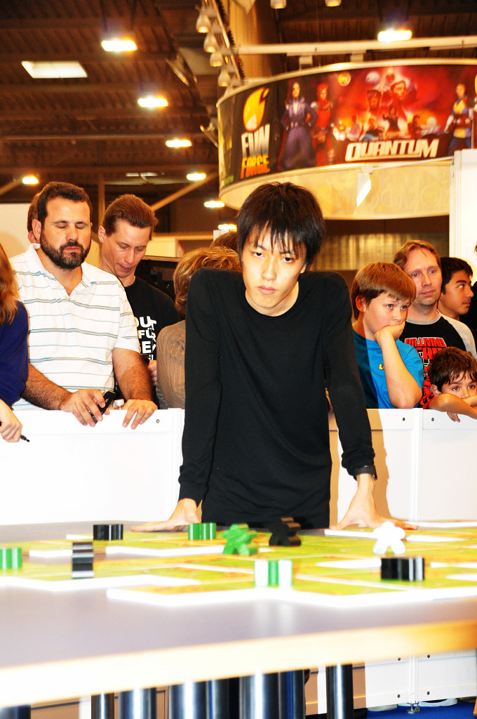 The japanese winner Takafumi Mochiduki at the traditional large finalisttable, with big tiles and meeples.